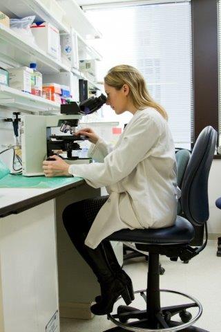 A cancer scientist using a microscope in one of our laboratories.