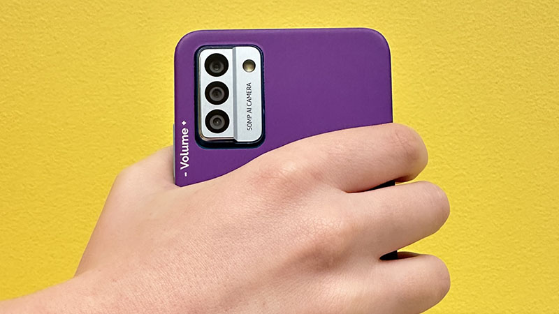 A purple backed smartphone being held in hand