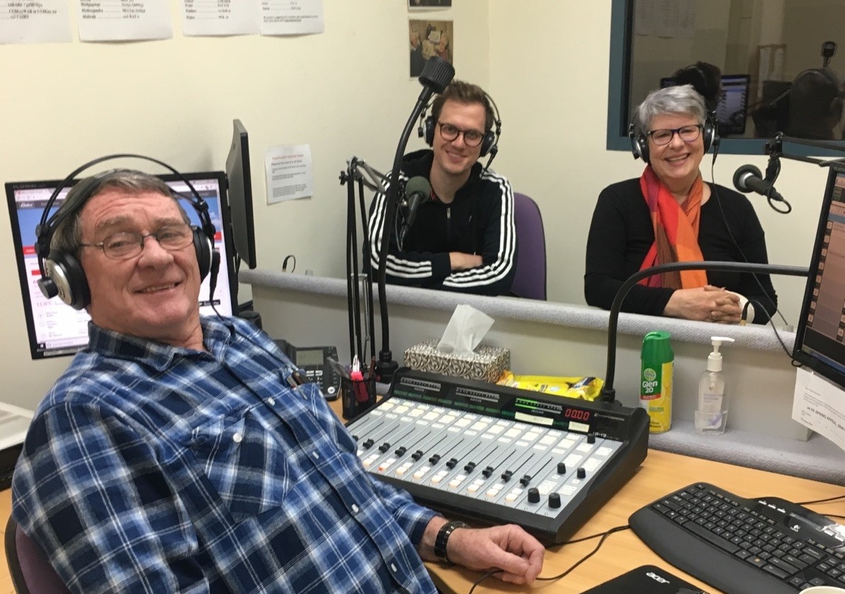 Three VAR volunteers sit in a VAR studio