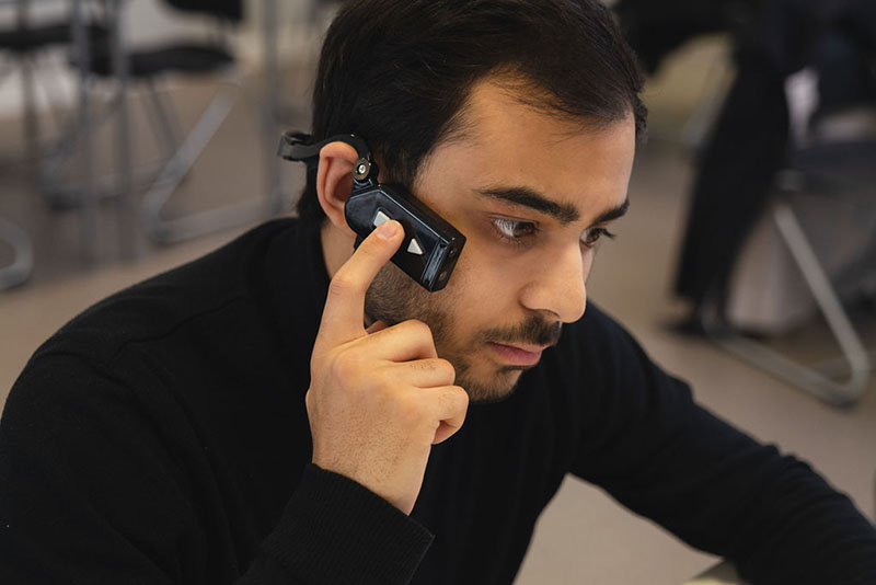 Man wearing the ARx headset, with his finger on a side button