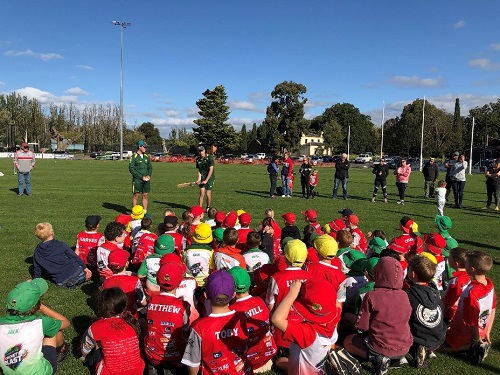 Blind cricketers Dan Pritchard and Johnny Boland explain the sport to a crowd of young players