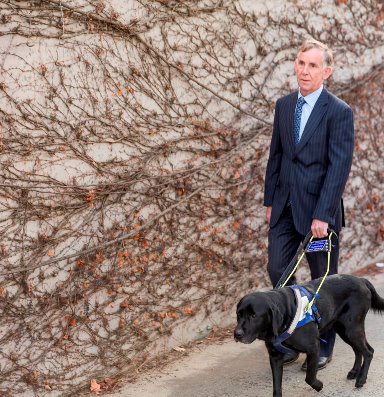 Kevin walking down a street with his Seeing Eye Dog Kane