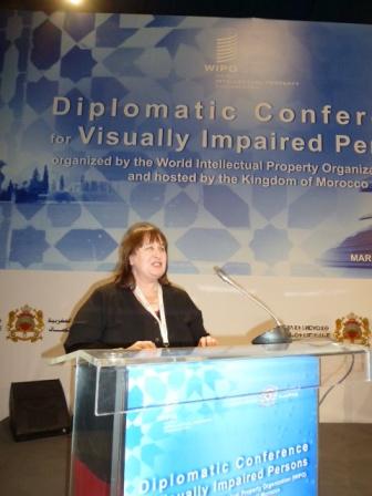 Maryanne Diamond speaking behind a lectern on stage at the conference