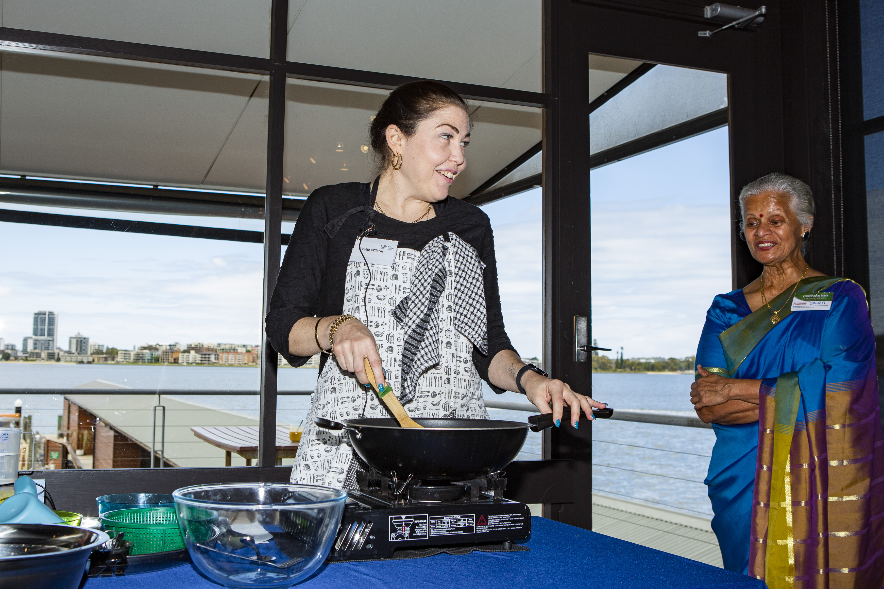 VA client Evette cooking with a staff member from Annalakshmi Culinary looking on