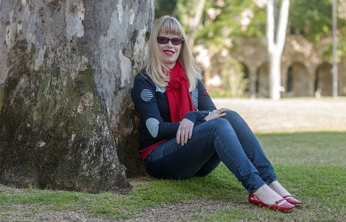 Jane sits outside against a large tree