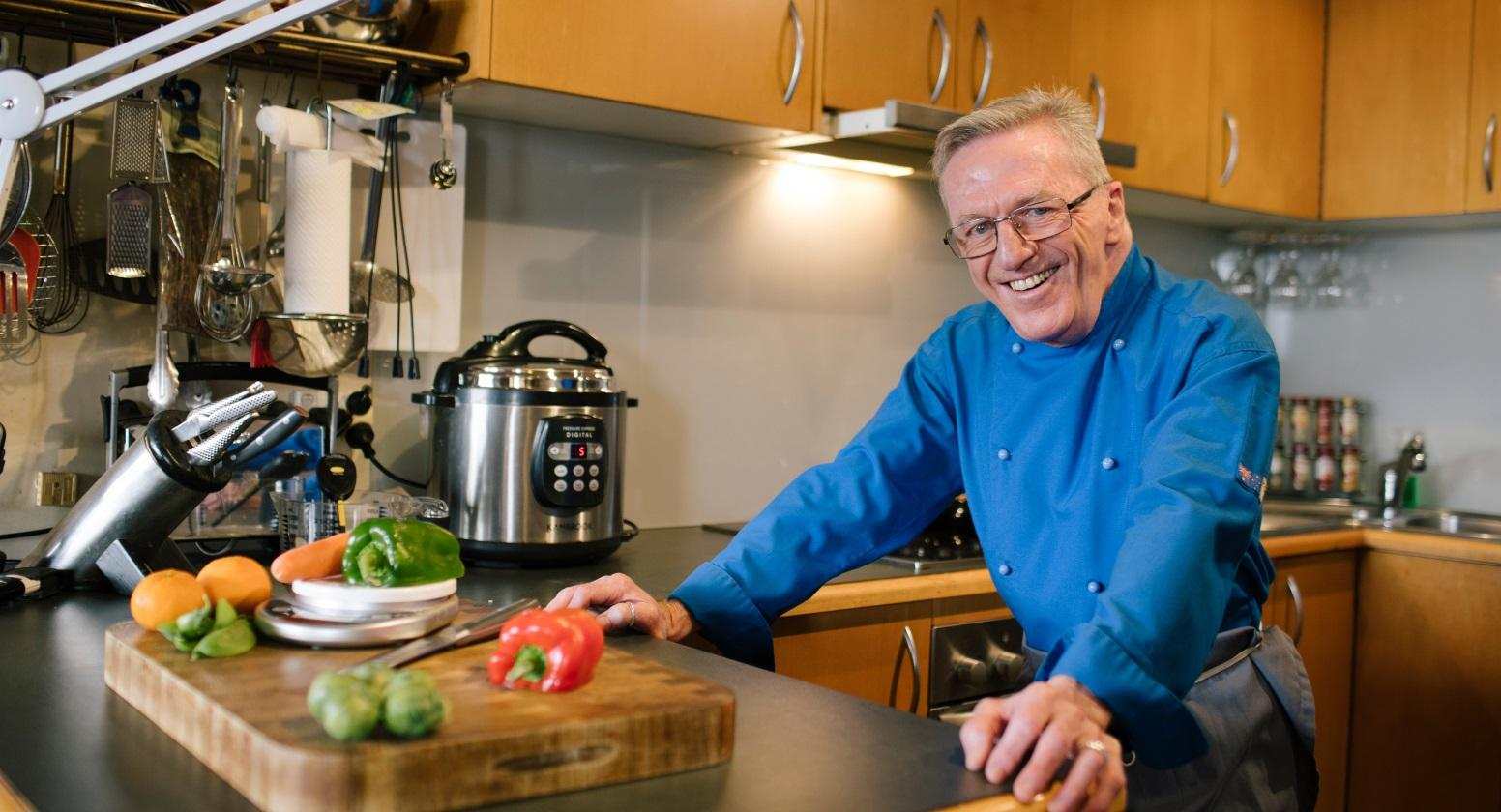 a man in a blue shirt, standing in his kitchen ready to cook. learn new emotional and practical strategies to continue to do the things you love.